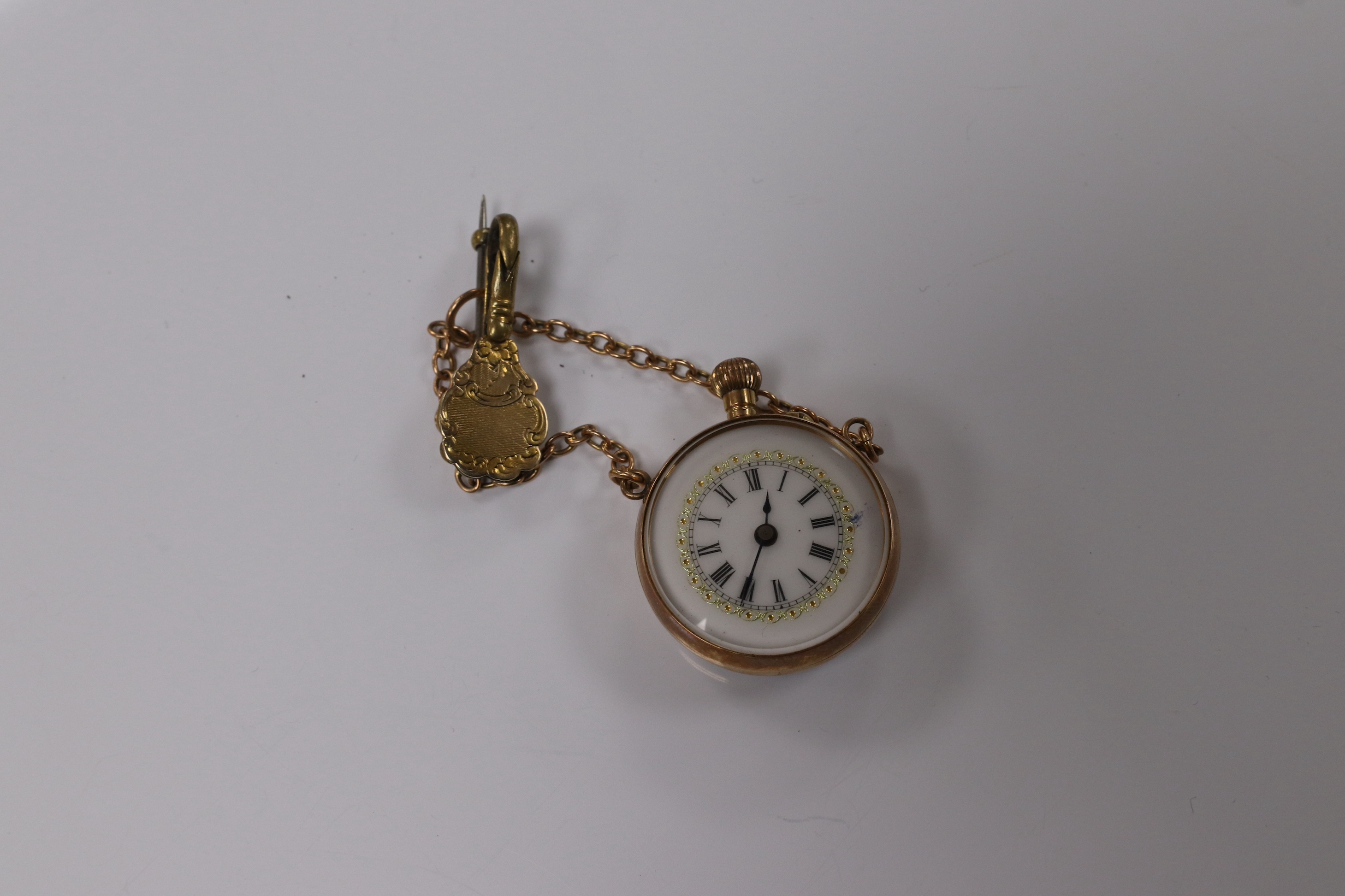 A lady's yellow metal mounted fob watch, with Roman dial and suspension chain with brooch, case diameter 26mm. Condition - fair